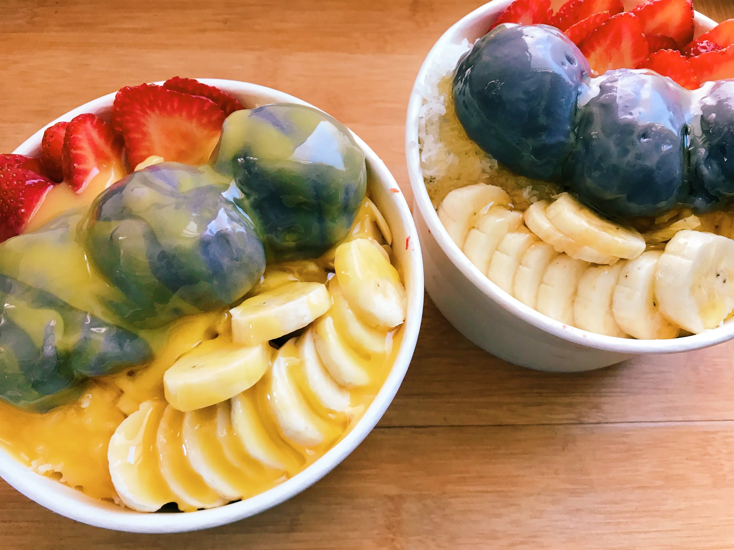 Two açaí bowls with liliko'i butter and banana